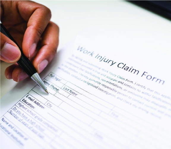 Image of a hand signing a work injury claim form. 