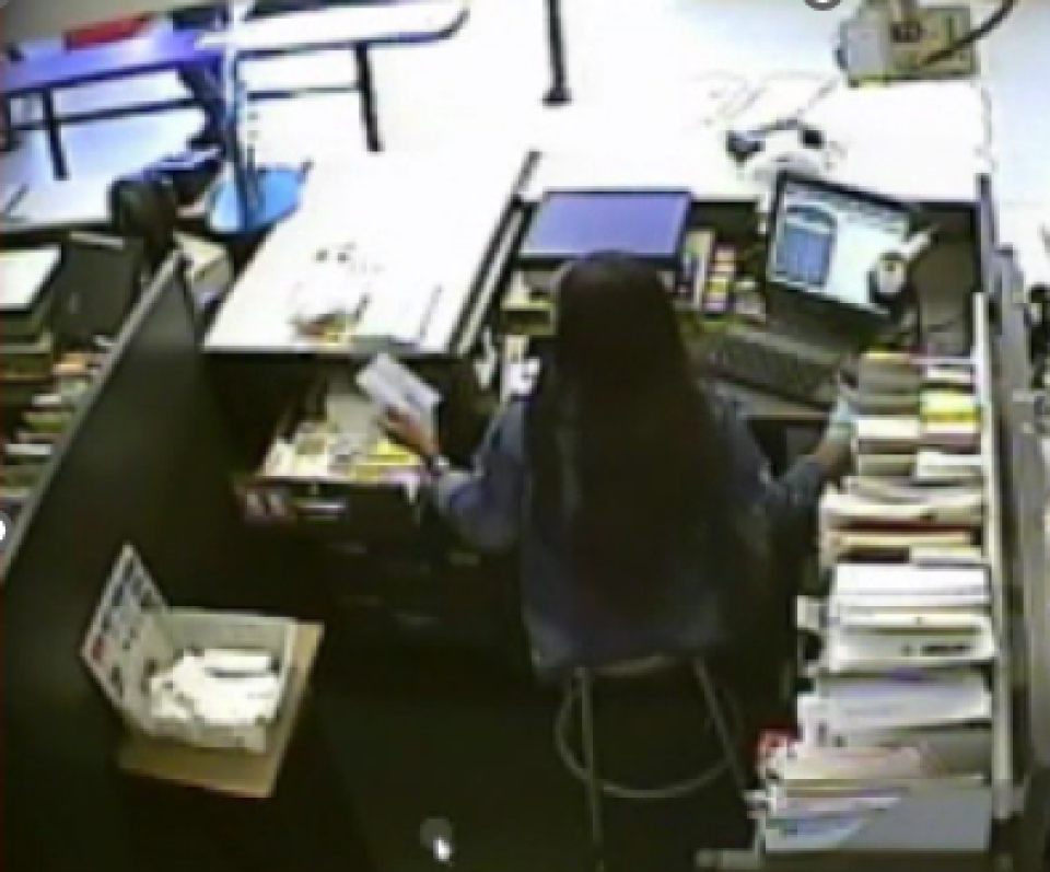 Serving no customer, the window clerk retrieves a money order from a side drawer to start the money order transaction.